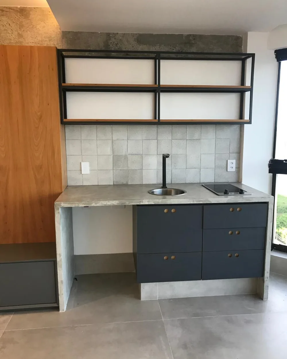Cozinha reformada com marcenaria e bancada em concreto