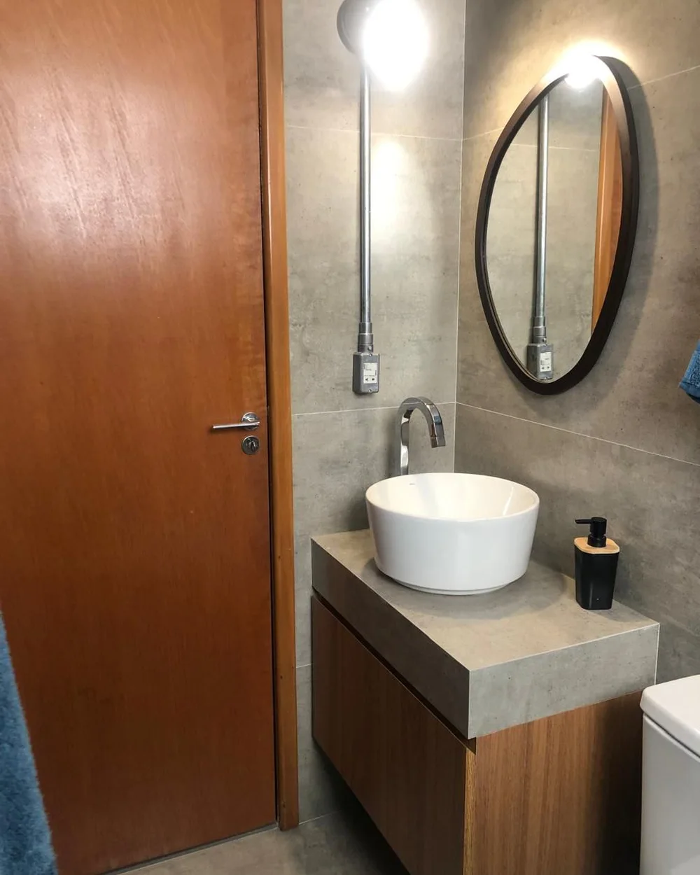 Lavabo reformado com bancada em concreto e espelho oval